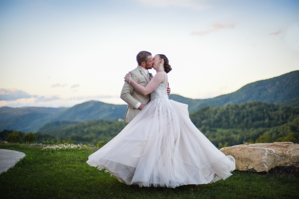 bride and groom kissing while overlooking north carolina mountains