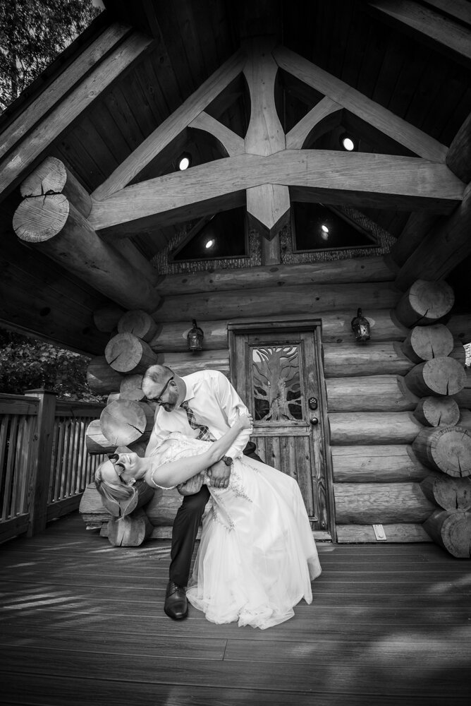 Gatlinburg mountain wedding groom dipping bride in front of tiny cabin