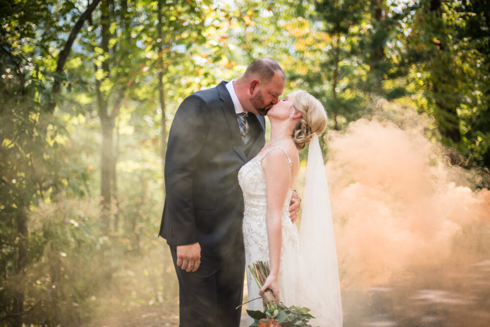 Gatlinburg mountain wedding bride and groom kissing with smoke behind them