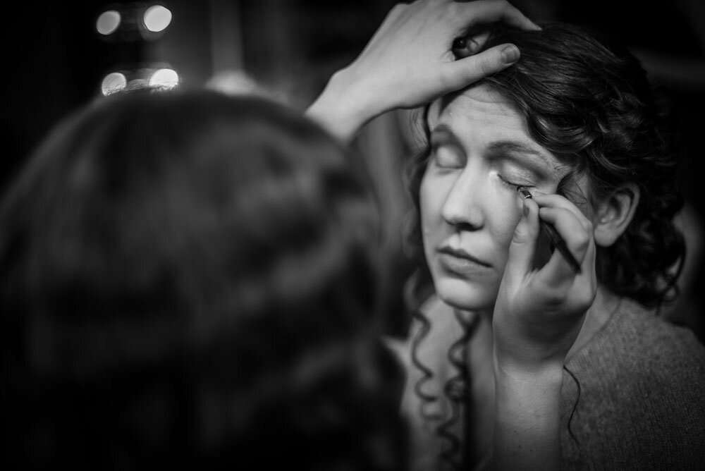 Bride having makeup put on as she gets ready for her wedding.