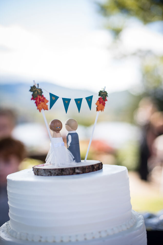 Wedding cake with topper looking out over Lake Junaluska