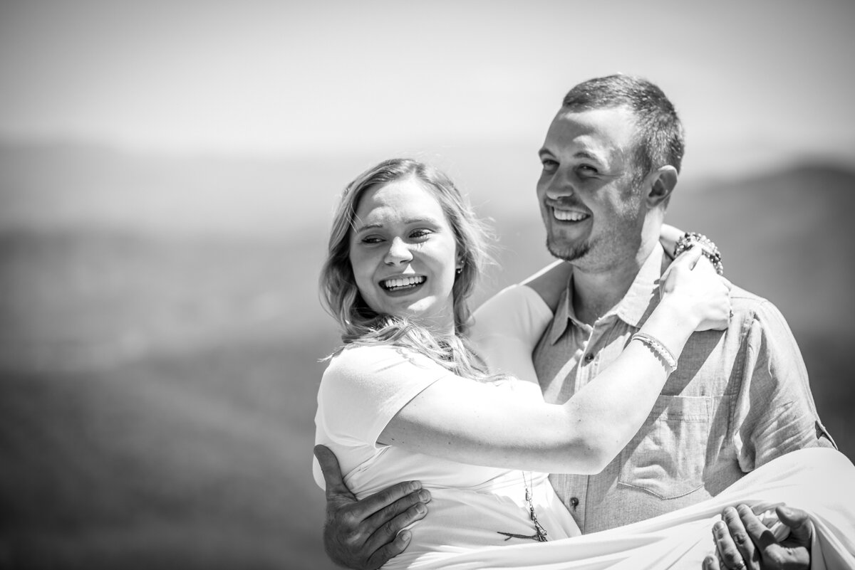 Groom carrying bride as they smile