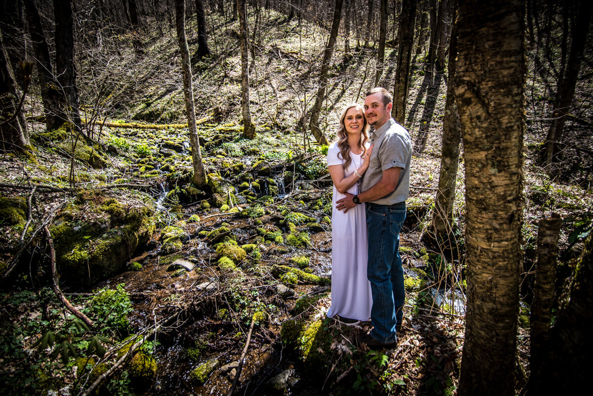 Bride and groom embracing each other in the woods at mountaintop elopement
