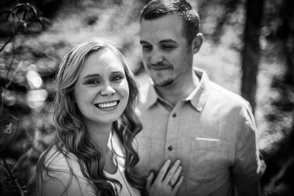 Bride smiling at camera and groom smiling at bride