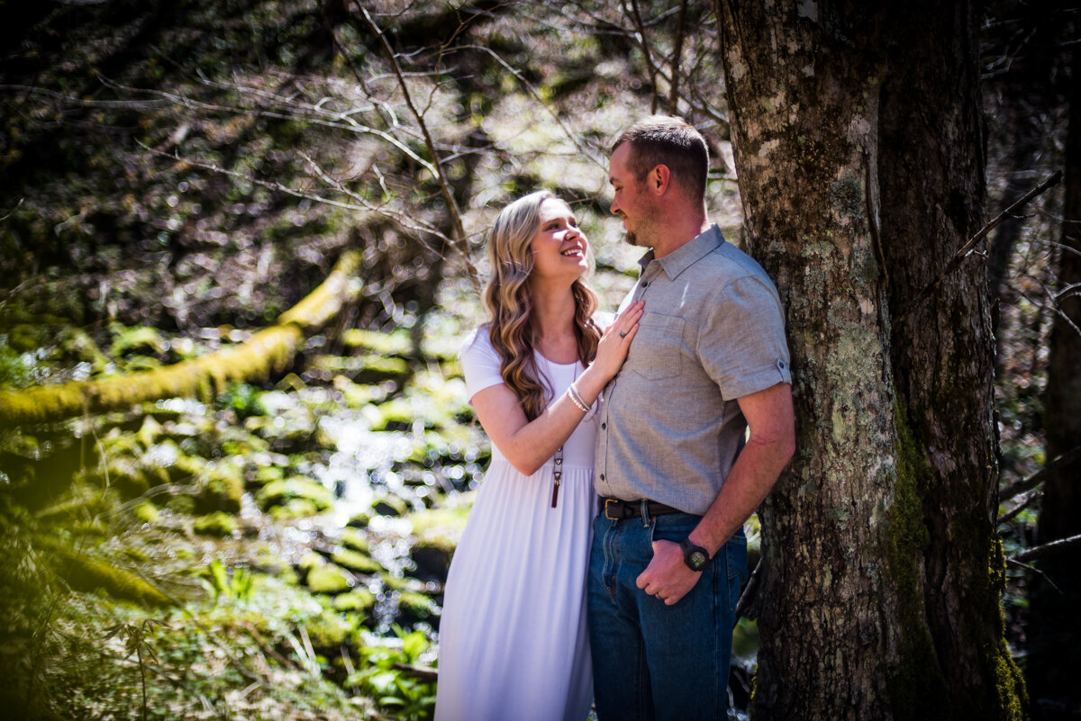 Bride and groom embracing each other in wooded area after mountaintop elopement