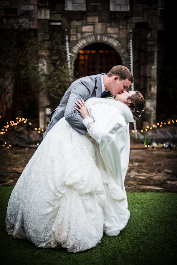 Groom dipping and kissing bride on the Castle of Joy lawn