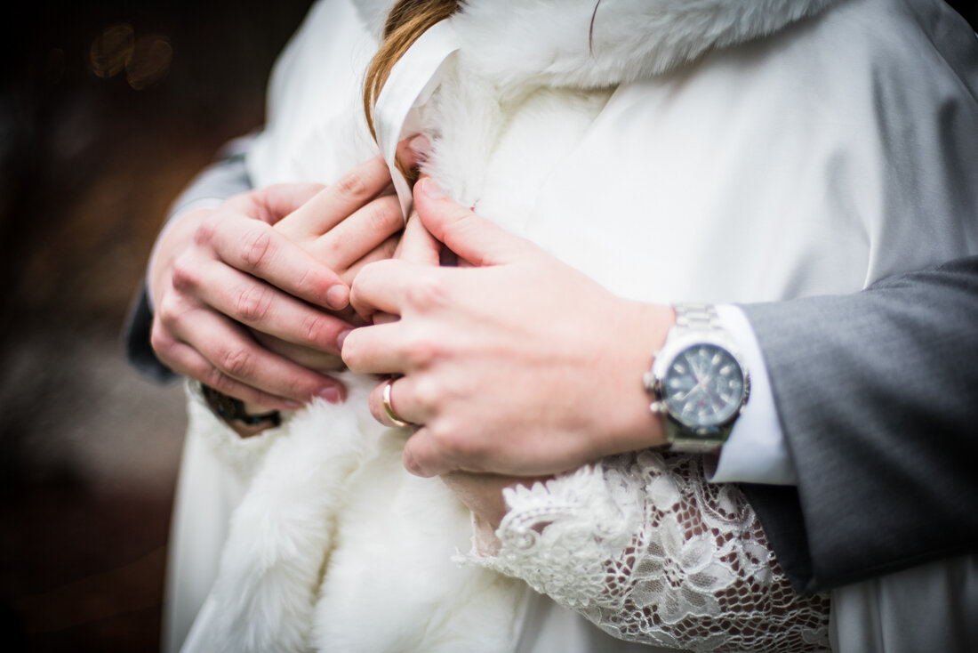 Groom's hands holding bride's hands