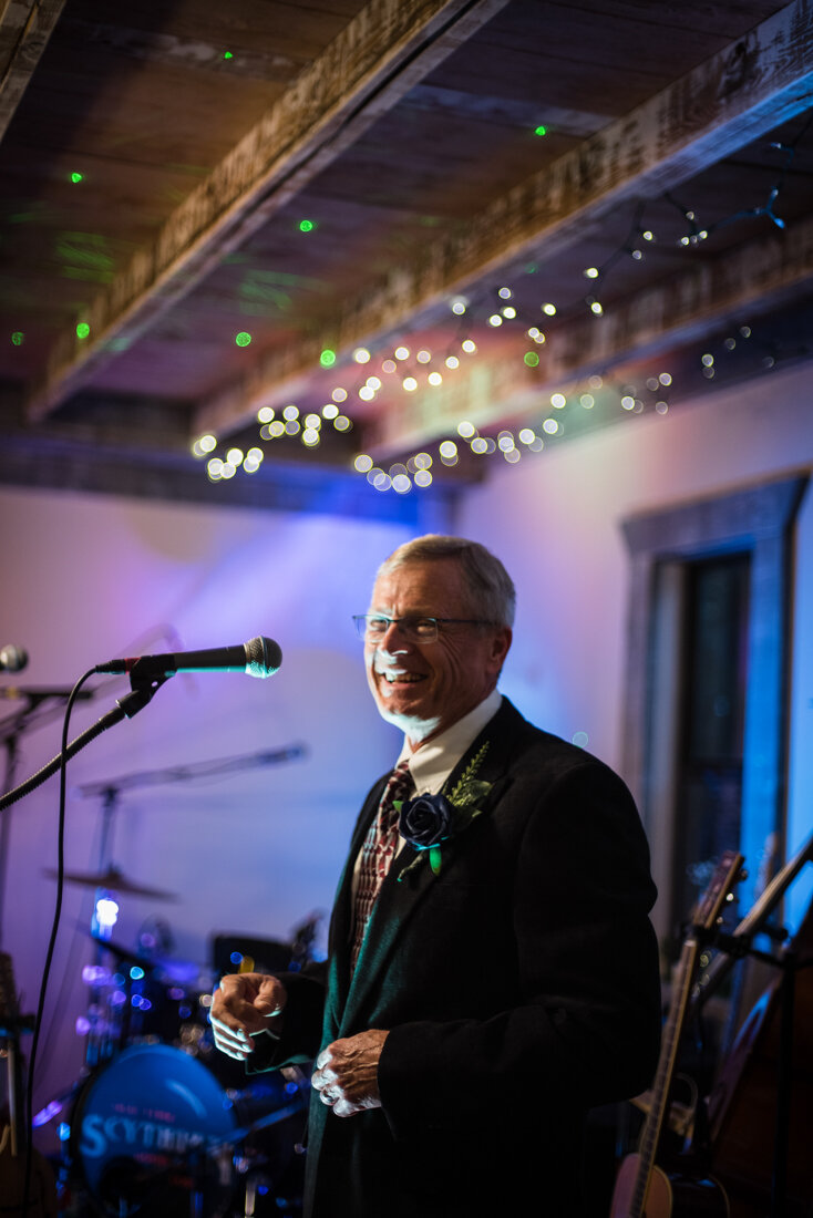 Man speaking into mic at wedding reception
