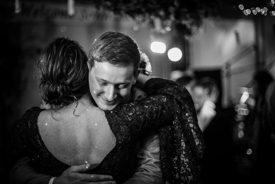 Groom and mother of the groom hugging after dancing at wedding reception