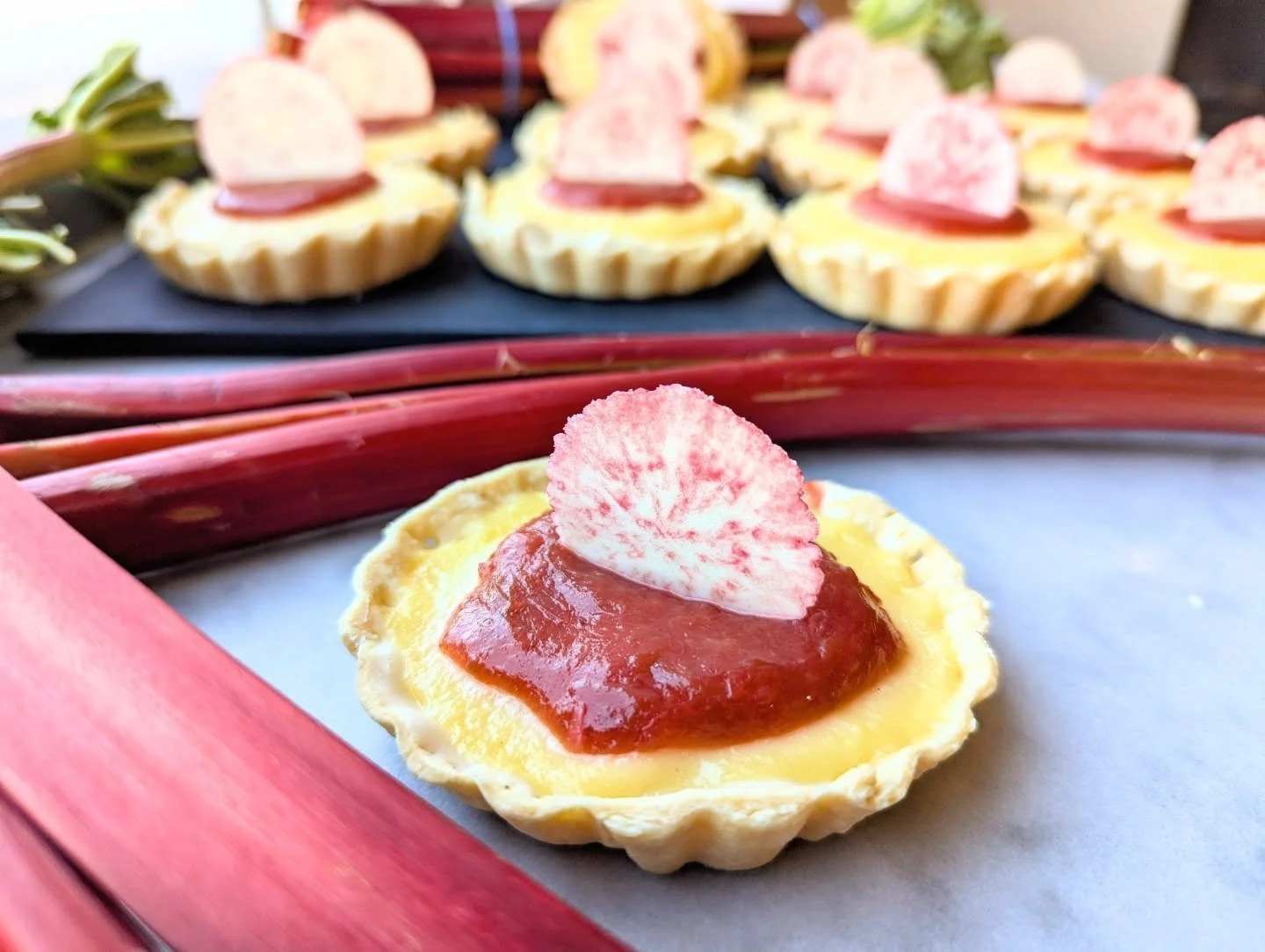 A little Monday special to take the edge off the start of your week. Rhubarb tarts!

A p&acirc;te bris&eacute;e crust with layers of white chocolate ganache, lemon curd, and rhubarb compote, topped with a tempered white chocolate raspberry medallion.