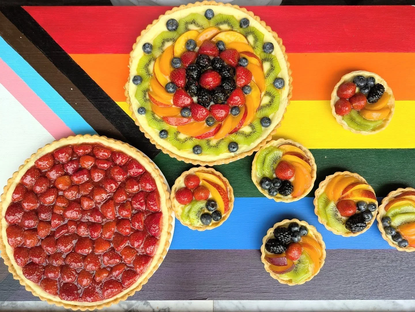 Okay so we're a little late with these rainbow fruit tarts, but we were busy celebrating Kalamazoo Pride this weekend instead of working ourselves to the bone.

But they're here now! Along with restocked strawberry tarts! And they're all fantastic. I