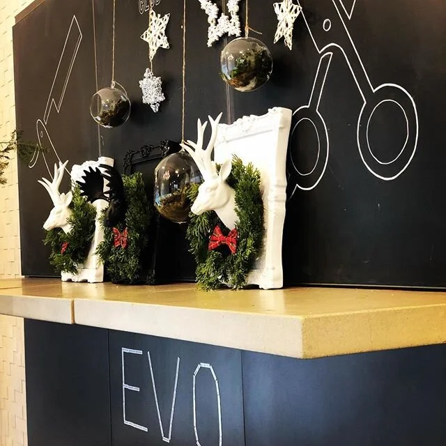 Holiday-decorated salon wall with chalkboard art