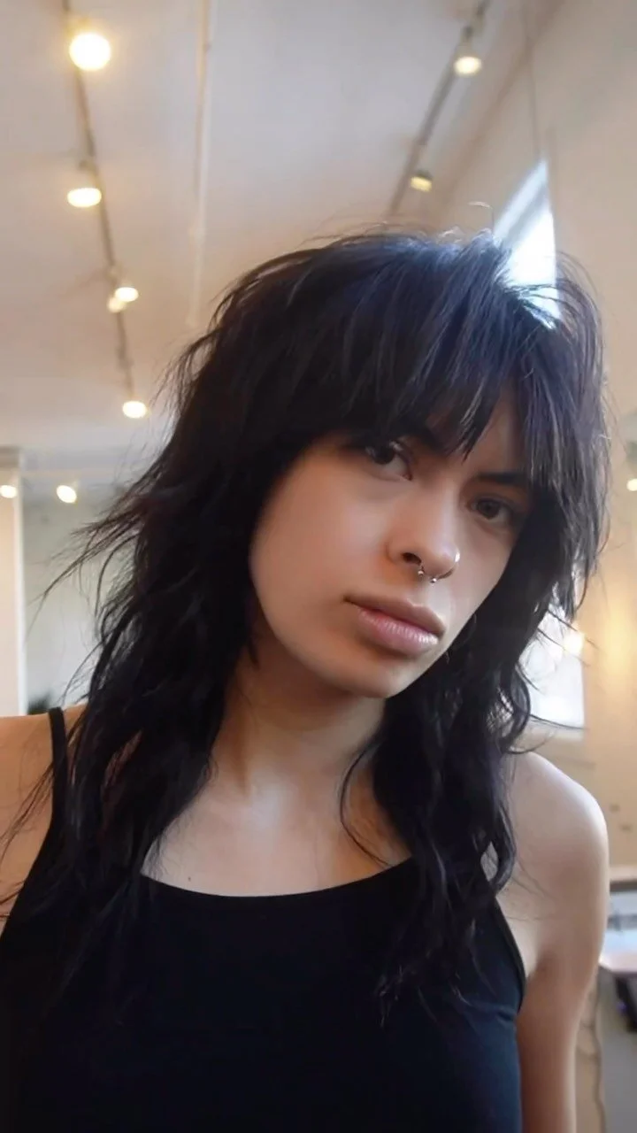 Dark shaggy layered hair on a person in a salon