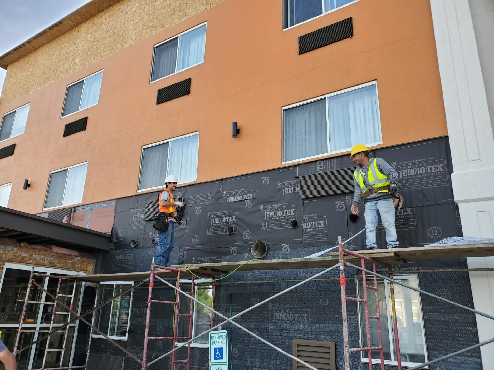 Construction workers on scaffolding repairing a building façade.