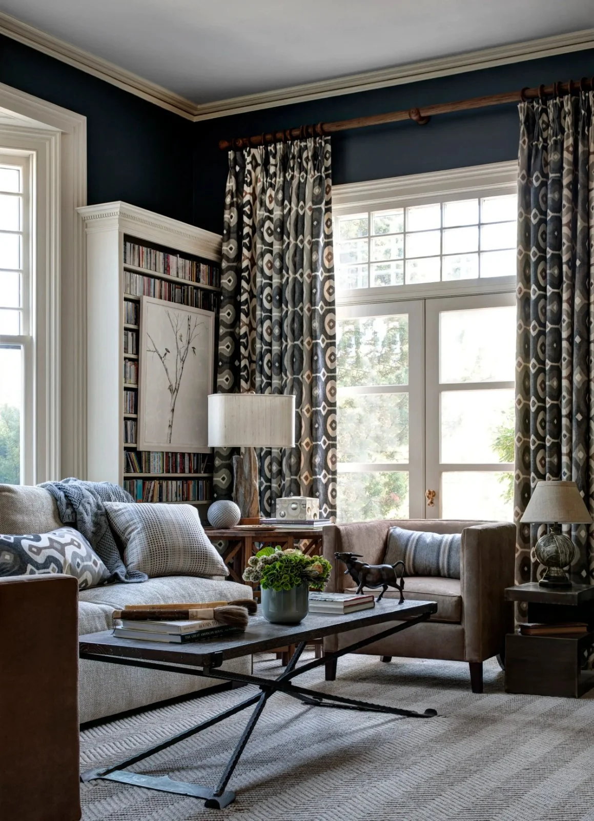 Custom patterned drapery and luxury window treatments in a designer living room with upholstered seating and tailored soft furnishings by MRV Exclusives