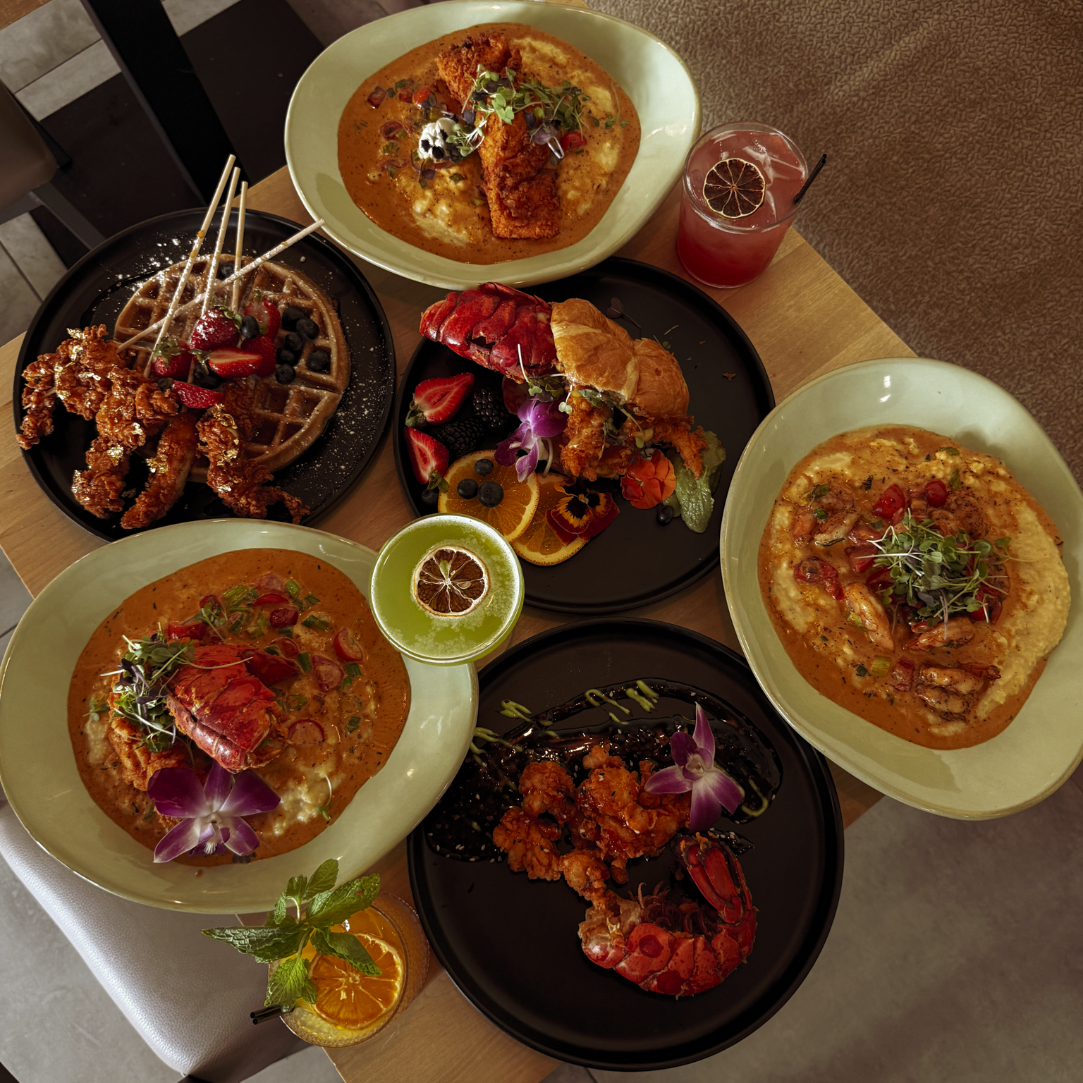 A full spread of premium seafood including stuffed salmon, chicken and waffles, and cocktails