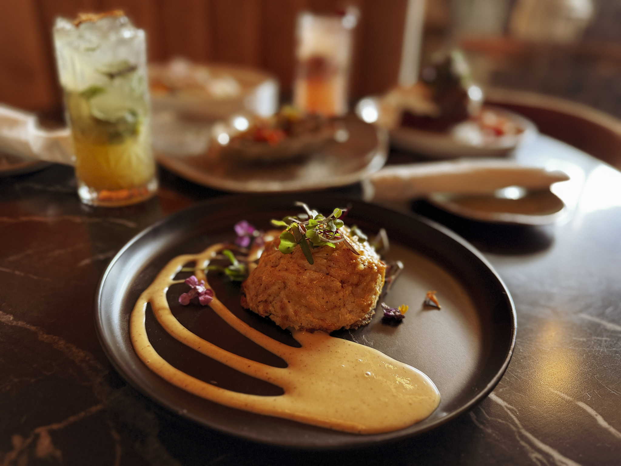 Jumbo lump crab cake with sauce swirls and cocktail at Crab Cab in Alexandria VA