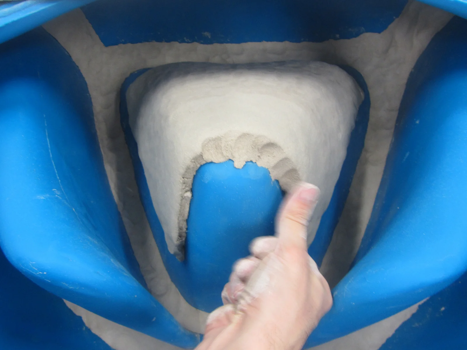 A view inside one half of the mold. Roughly 150 kg of clay is pressed into the mold by hand. The surface is covered from the inside to a thickness of 1.5 cm by laying up 1.7 cm thick slabs. A special pressing technique was developed to maintain a un