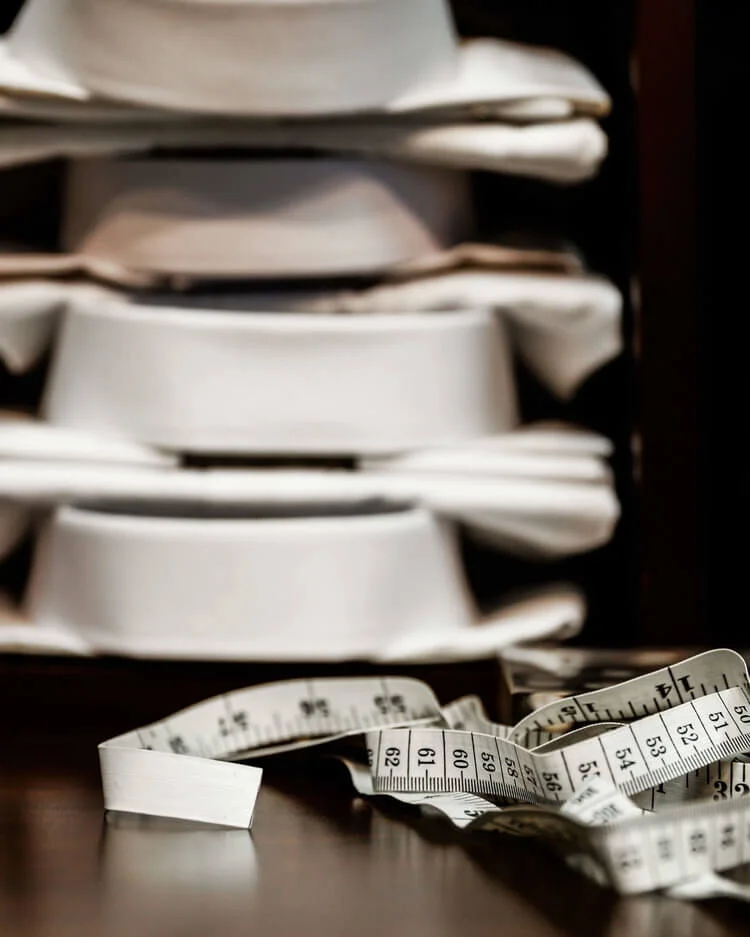 yacoubians-tailors-photography-stacked-shirts-measuring-tape.jpg