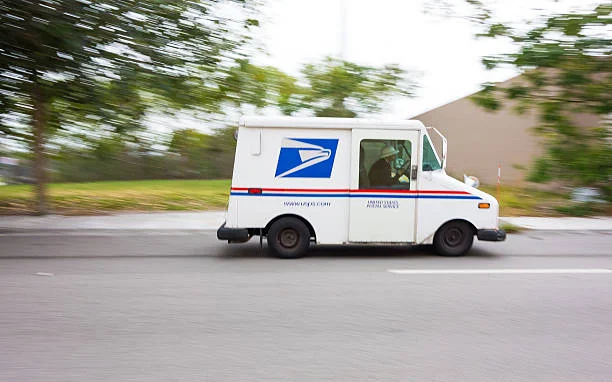 Miami, USA - January 18, 2013: United States Post Office mail truck (USPS) speeding in Miami, Florida - motion blur panning.