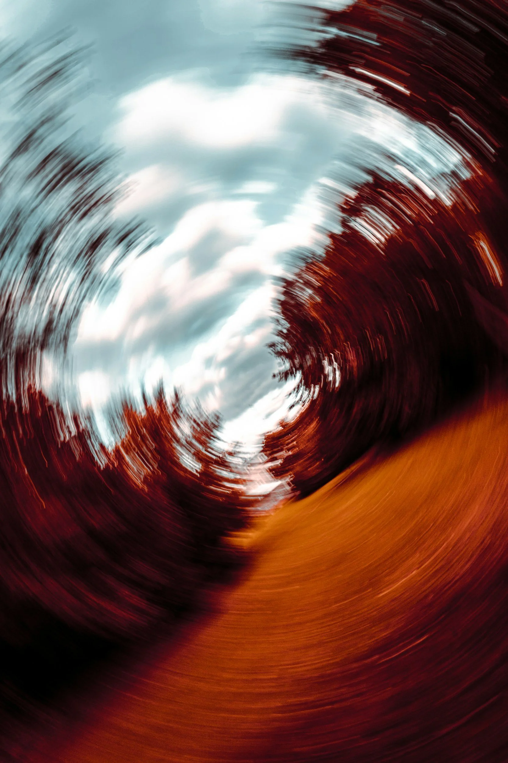 Blurry photo of trees with a cloudy sky, taken with a swirling motion effect.