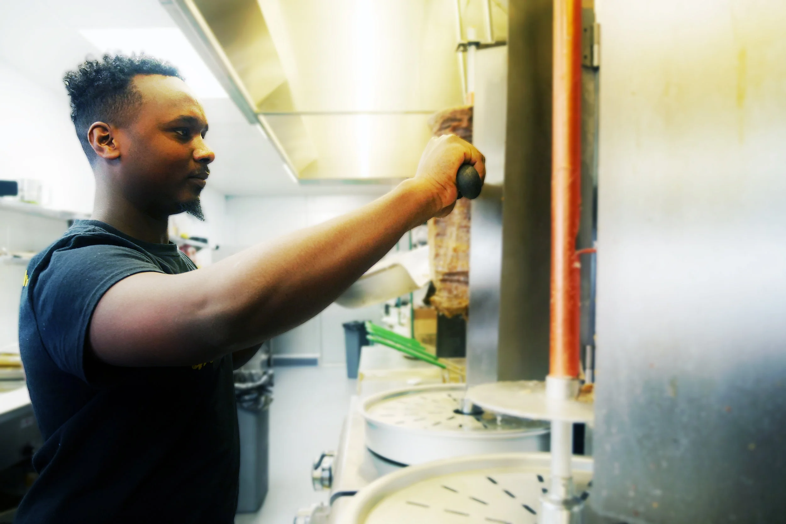 Abdi Ali works the deli counter in Karibu