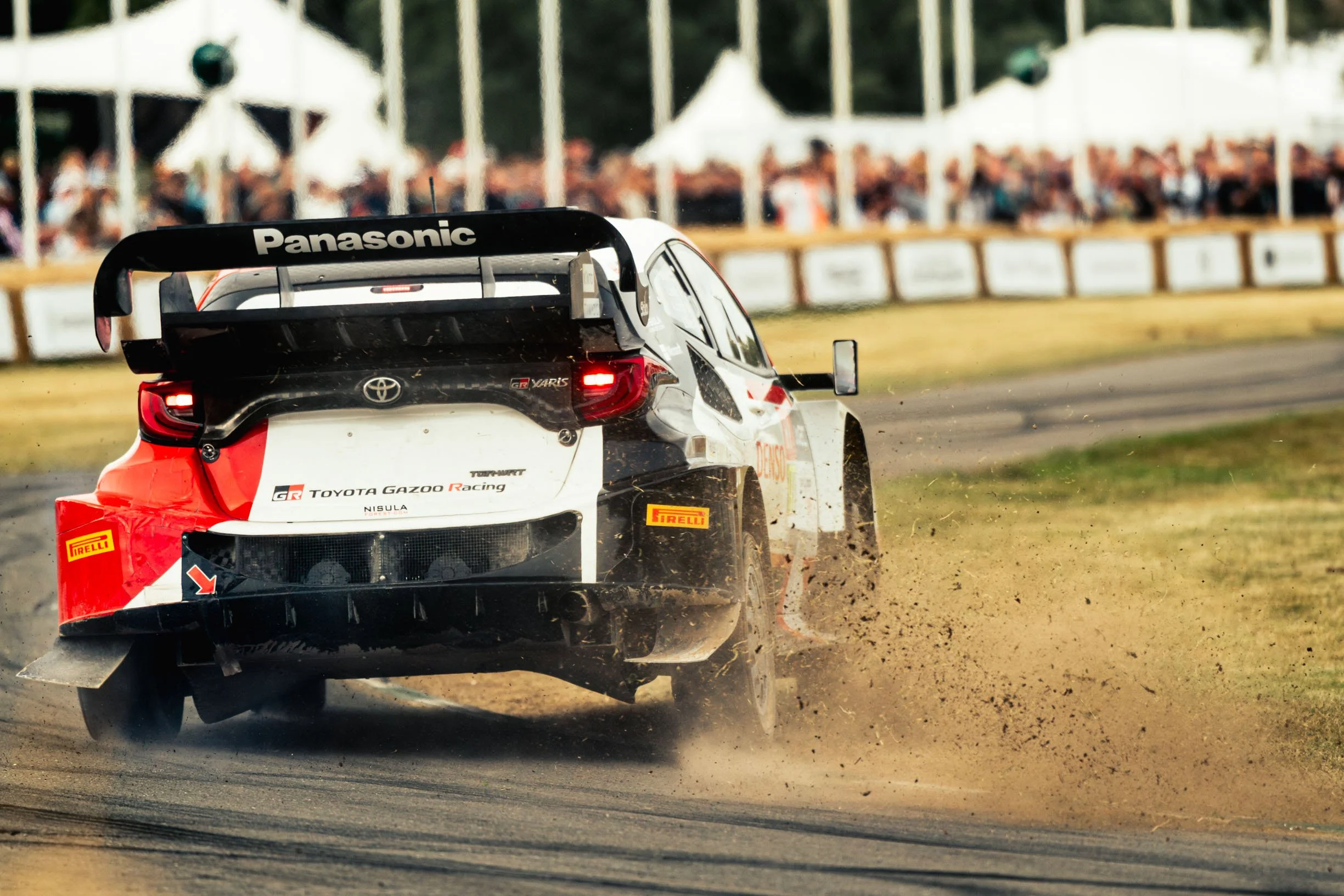  The Toyota Gazoo Racing GR Yaris Hybrid Rally 1 drifting around the corner on the grass at the 2023 Goodwood Festival of Speed Chichester, West Sussex. 