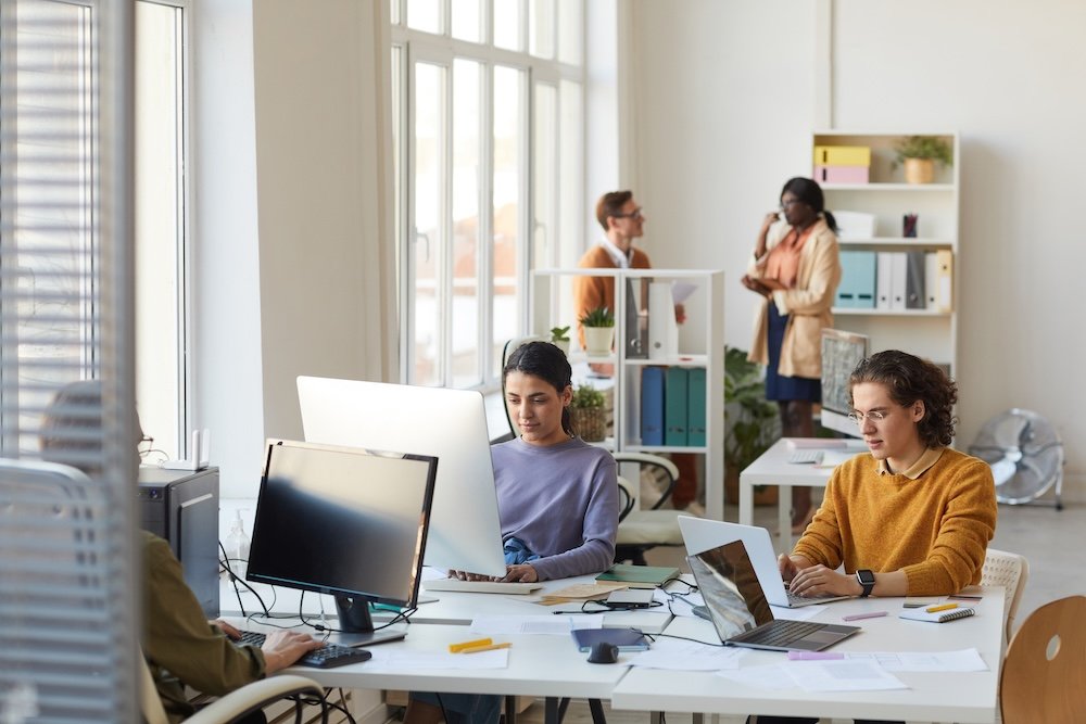 Office space for rent featuring a bright open workspace with professionals collaborating in a modern office environment
