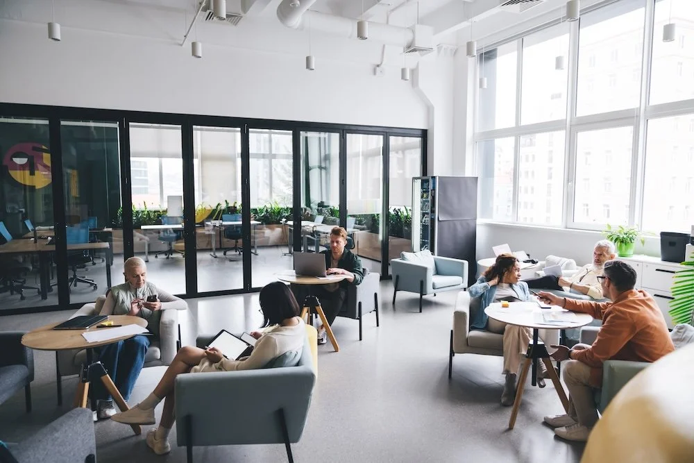 Modern office lounge with professionals collaborating in a bright workspace, illustrating different office building classes