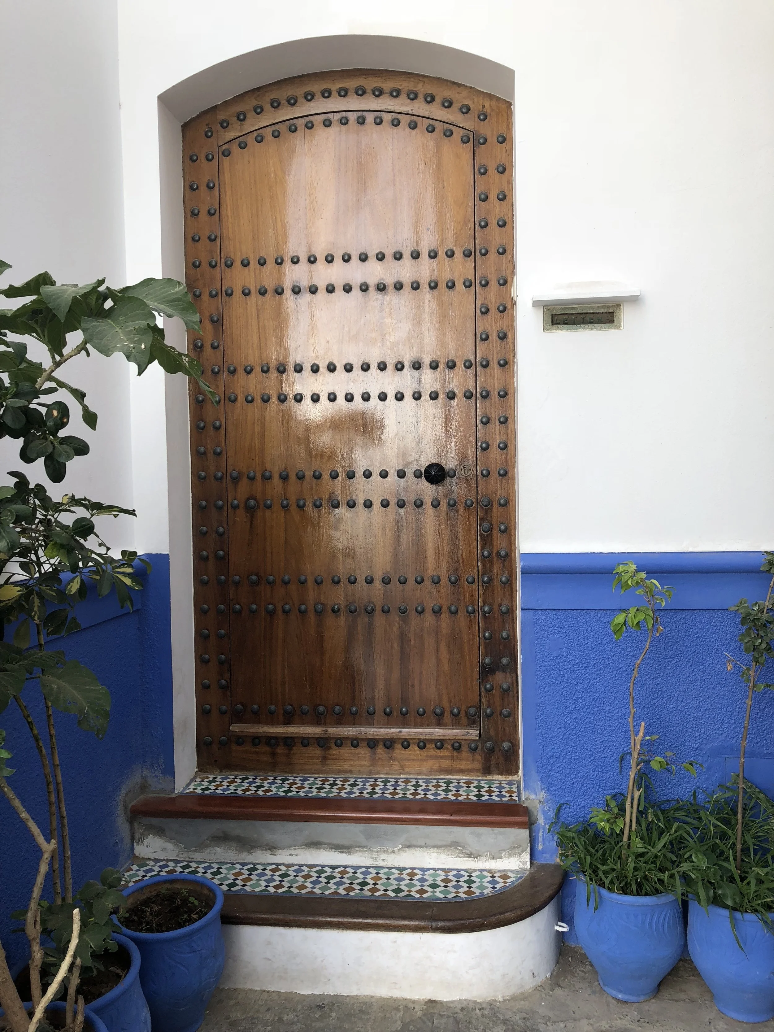 Riad door with Majorelle blue walls and Moroccan tiled steps