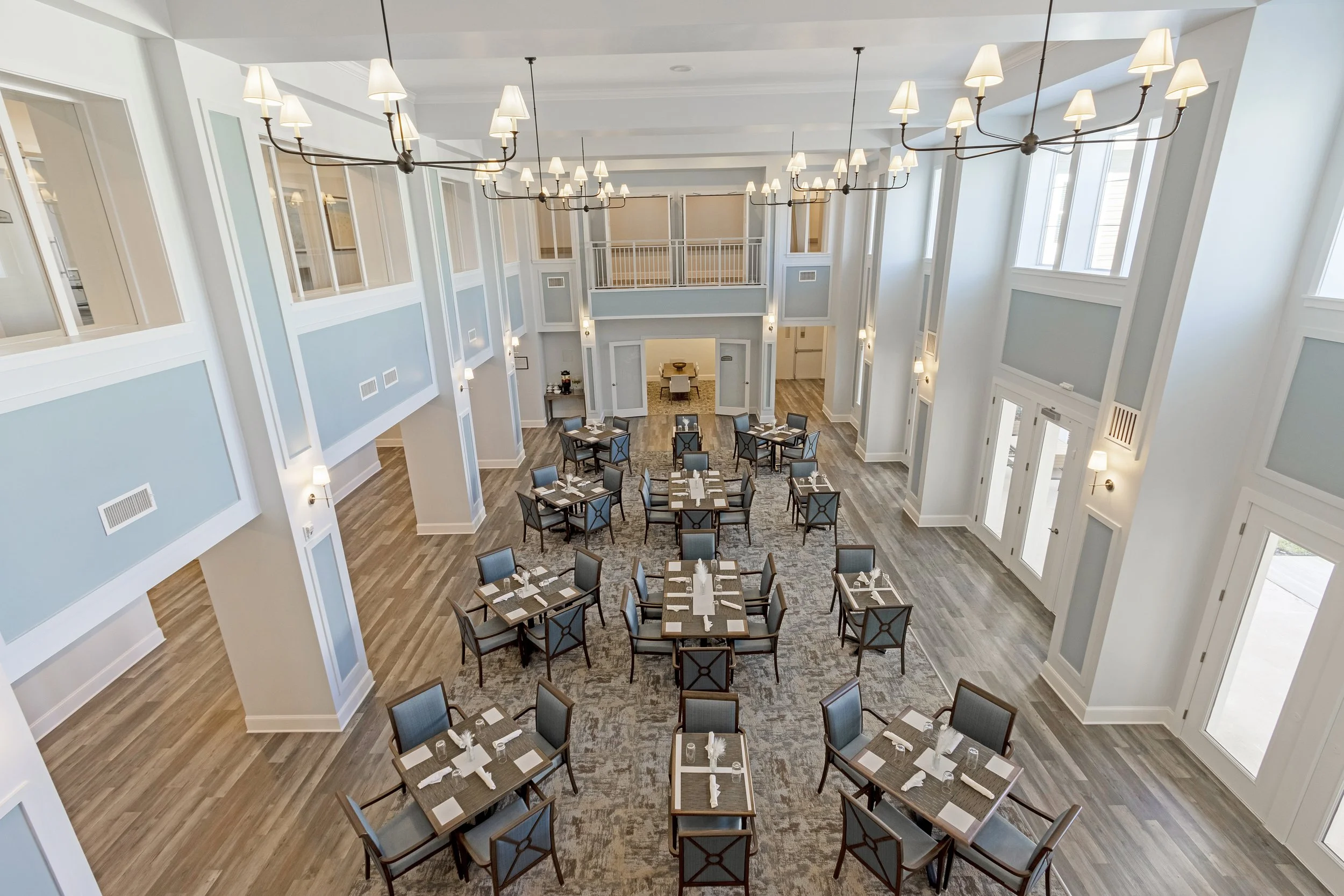 Micamy Design Studio_Canopy at Beacon Woods_Dining Room_Two Story_Spacious_Chandeliers_Carpet Inset_Sqaure Tables_Social_Blue_Wall Sconce .JPG