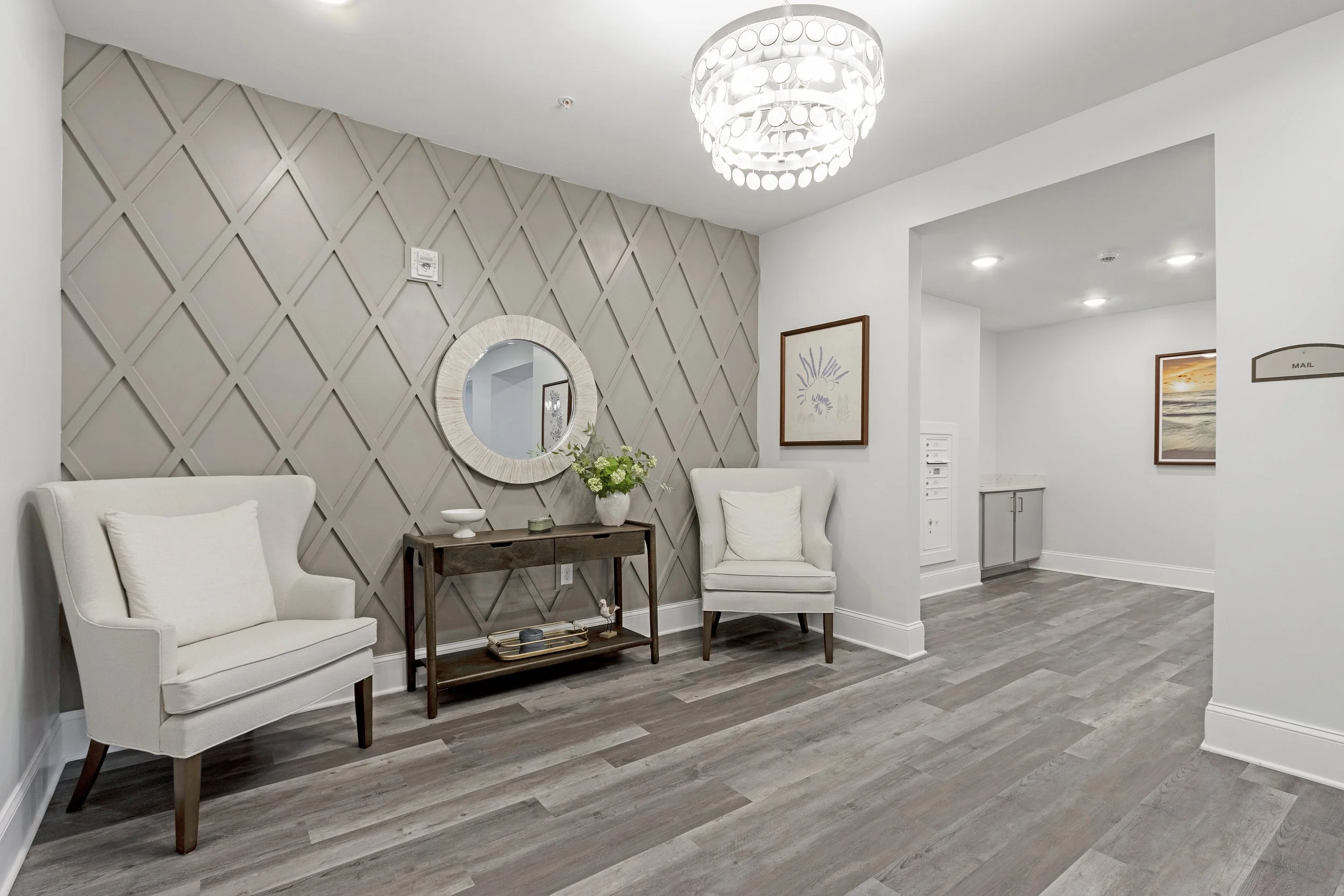 Micamy Design Studio_Canopy at Beacon Woods_Mailroom_Guest Chairs_Accent Wall_Decorative Trim_Chandelier_Mirror_Artwork_Signage_Luxury Vinyl Tile.JPG