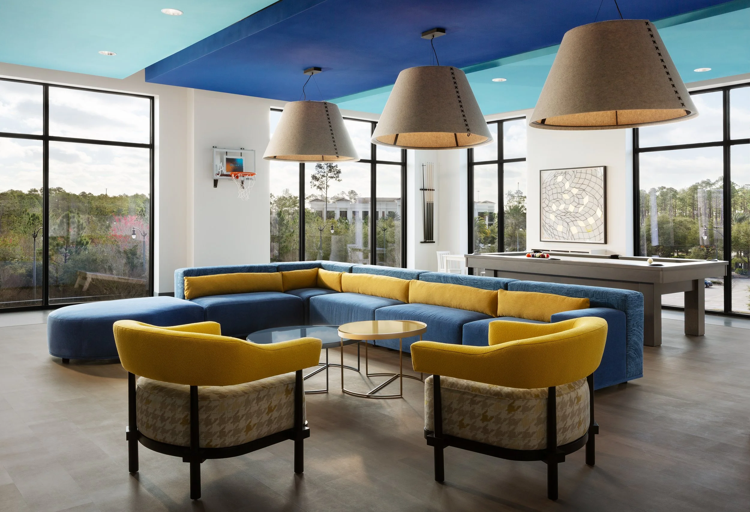 MicamyDesignStudio_EasyCare_Commercial Office_Lounge_bright bold colors_three large buzzispace pendants_oversized blue sofa with yellow pillows.jpg
