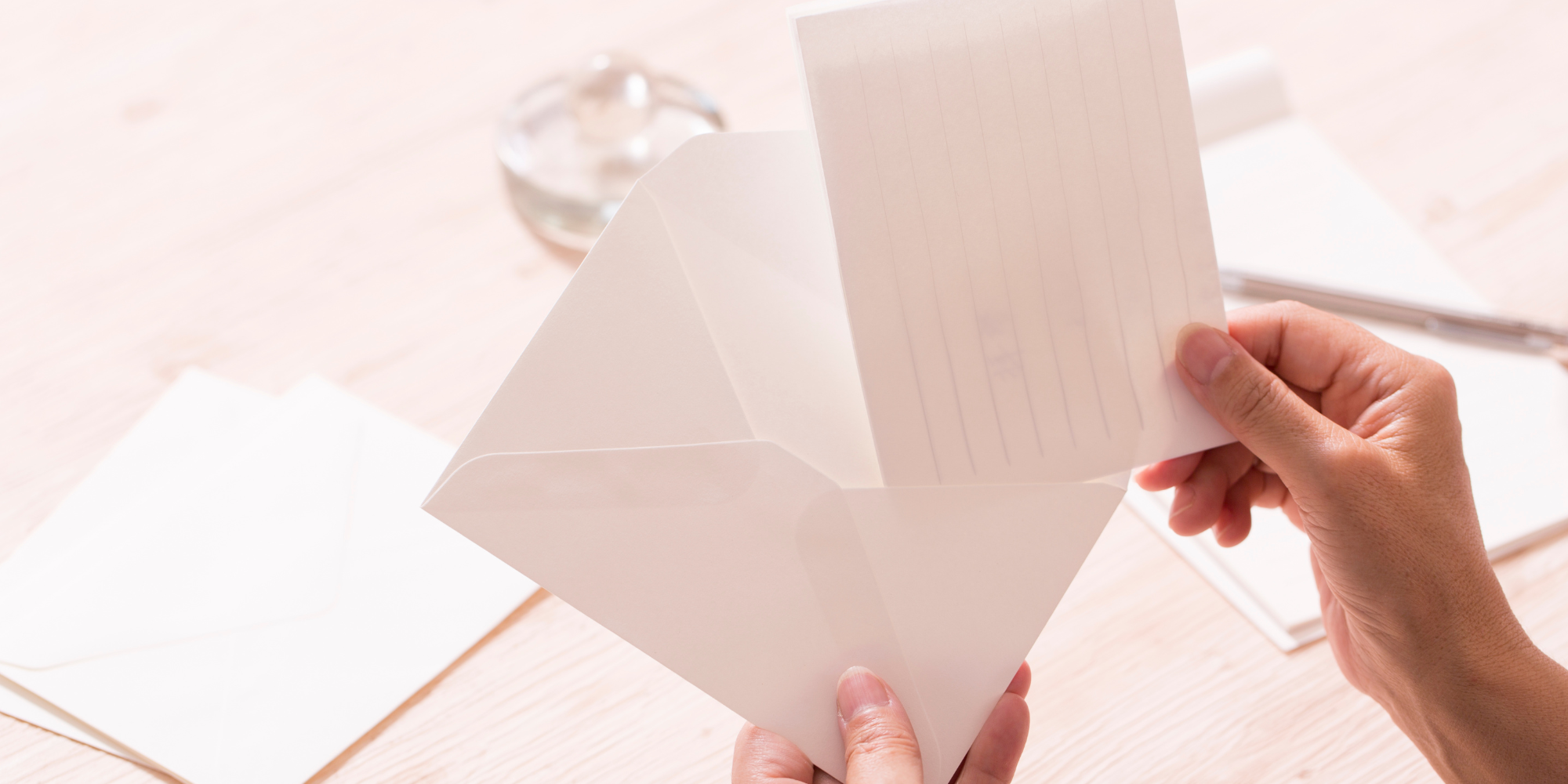 An image of a person putting a letter into an envelope