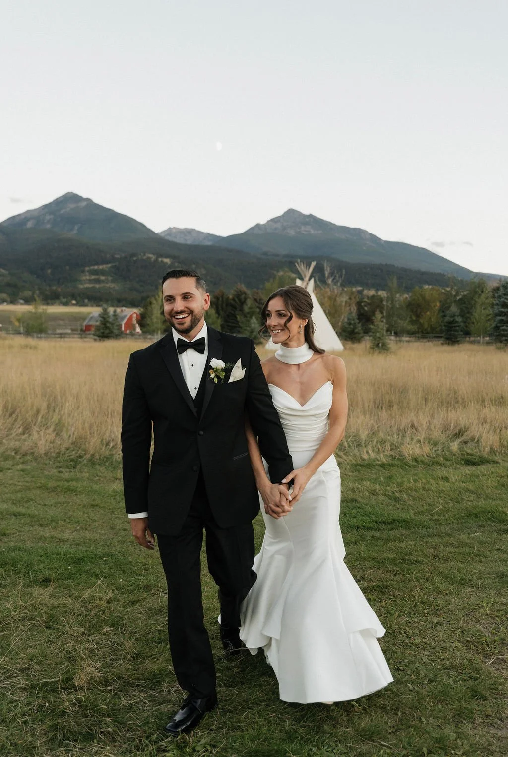 goldenhour photos with the sun on the mountains and the bride and groom holding hands and looking in different directions while walking