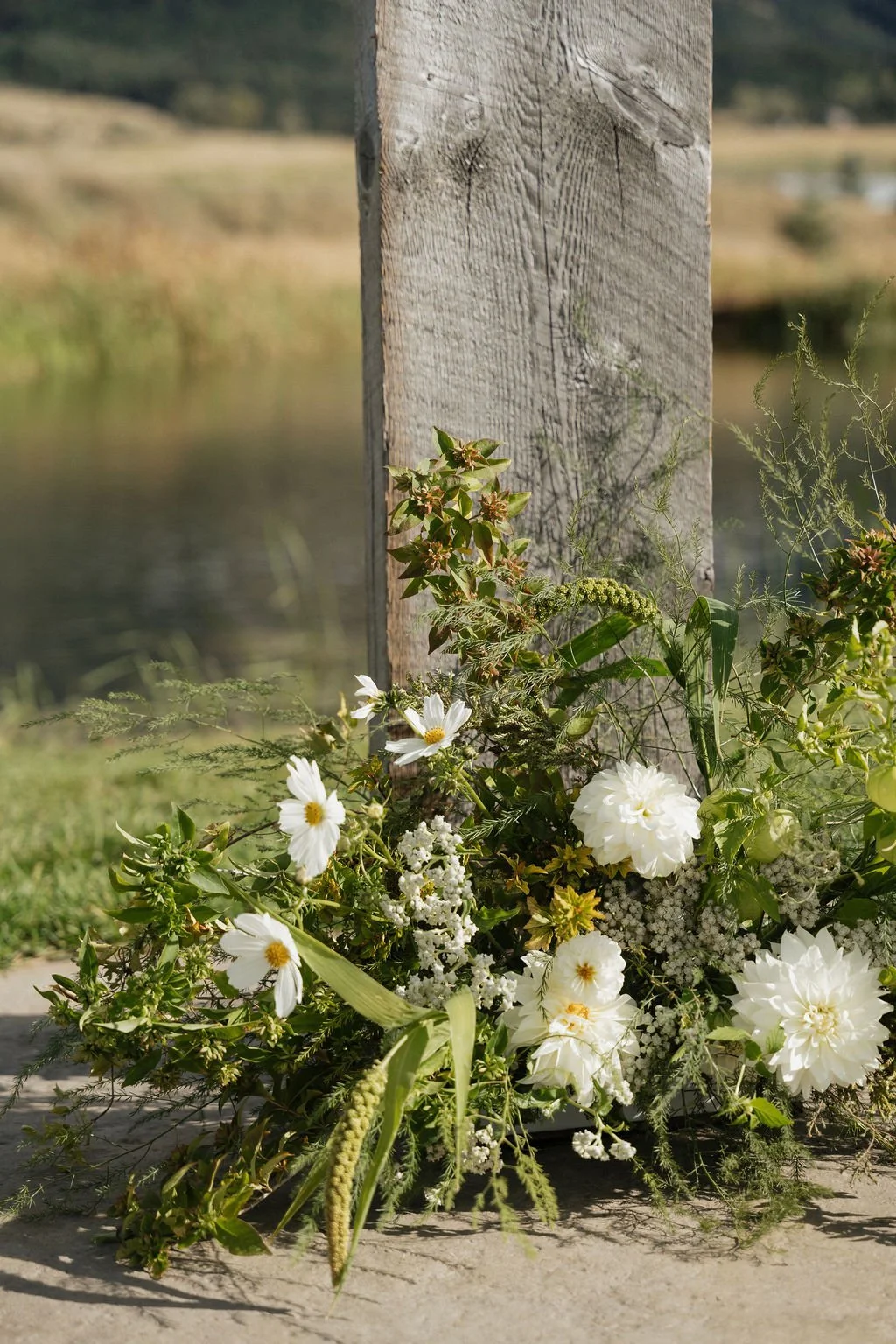 a close up shot of the floral arrangements at the base of the arch