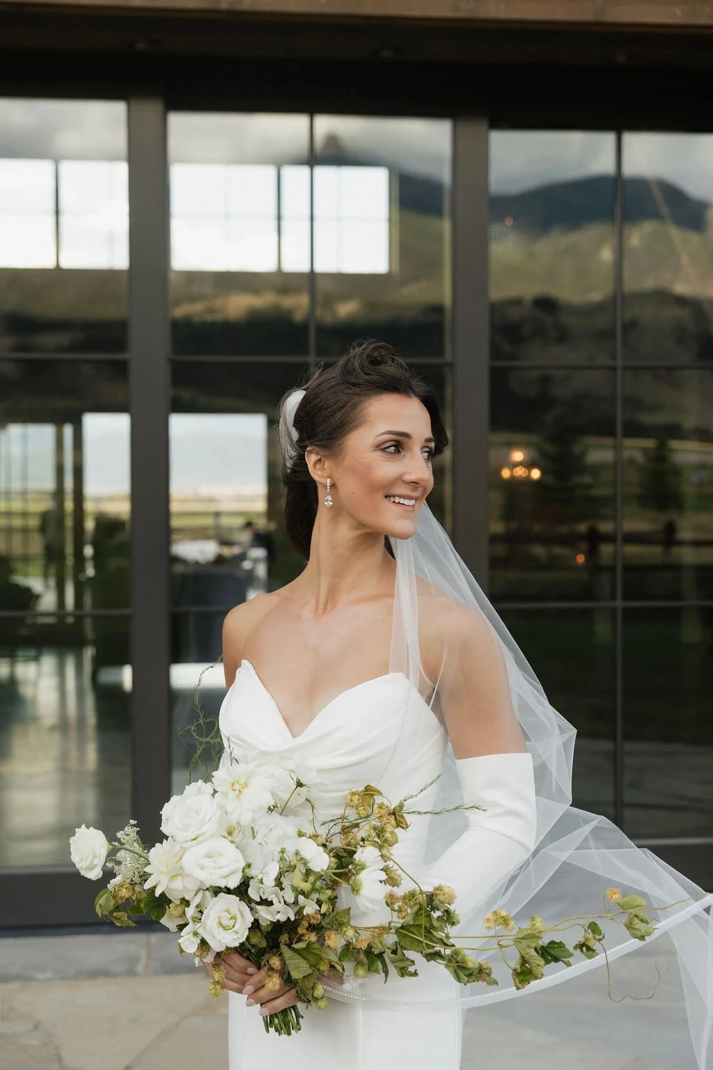 bride with her bouquet and a beautiful white and green hops bouquet with white florals and local seasonal flowers and dahlias
