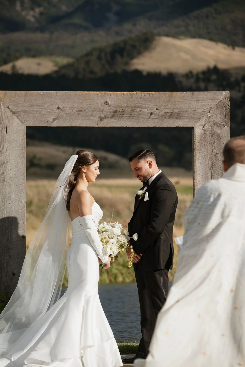 bride and groom listening to the catholic ceremony with the bride holding her bouquet