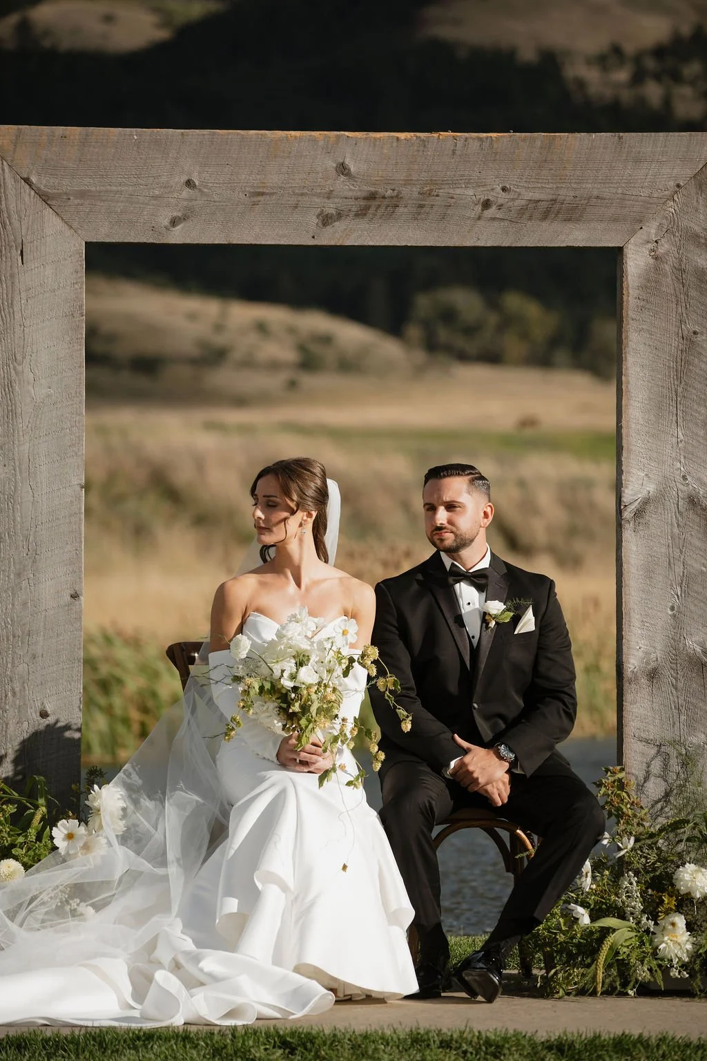 bride and groom sitting listening to the catholic ceremony with the bride holding her bouquet