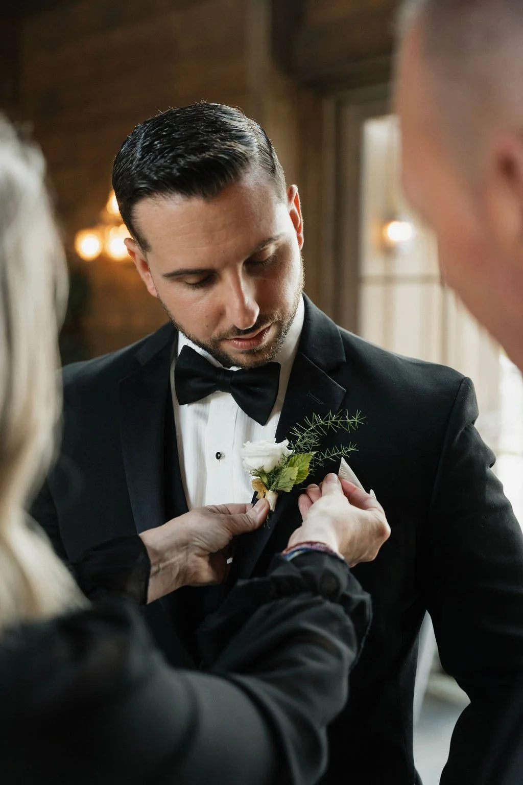 the groom's mother affixing his boutonniere