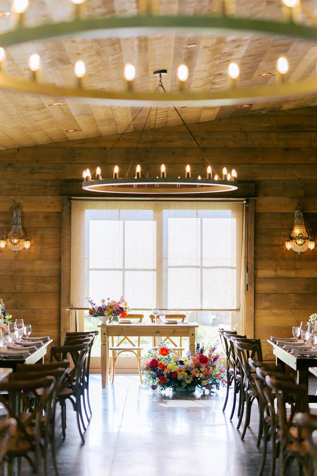 Wider angle on bright florals decorating sweetheart table