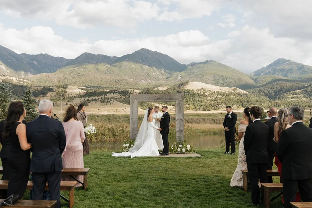 a wide angle shot of the guests watching the bride and groom share their vows