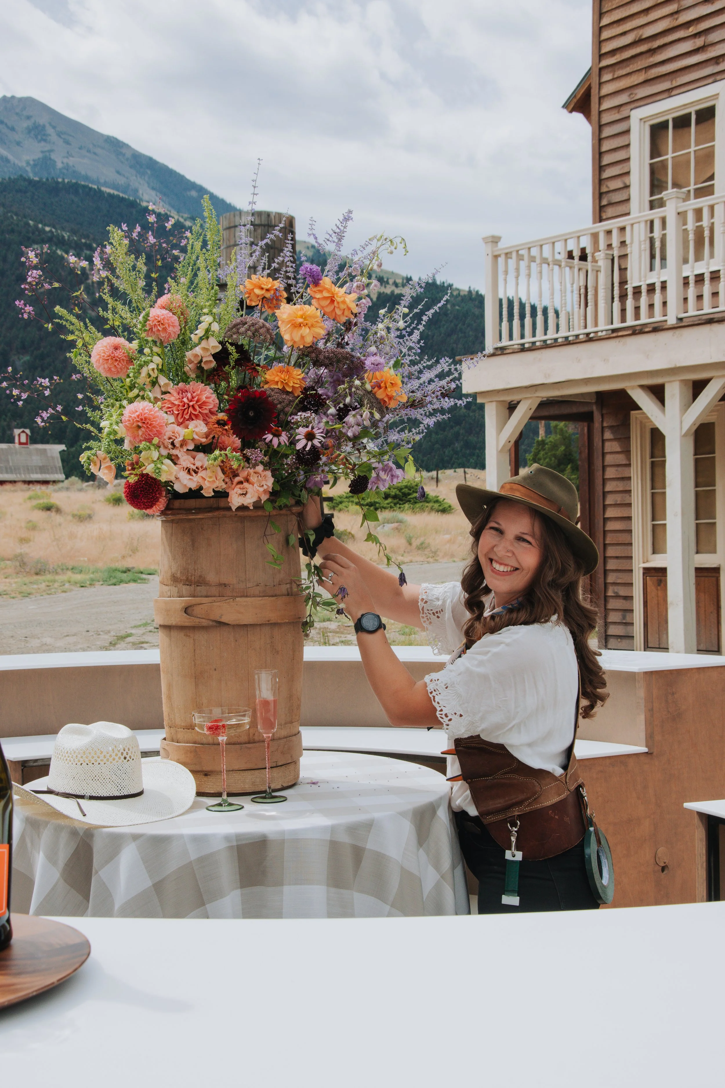 Hannah Ohman arranging flowers on a round bar for an event