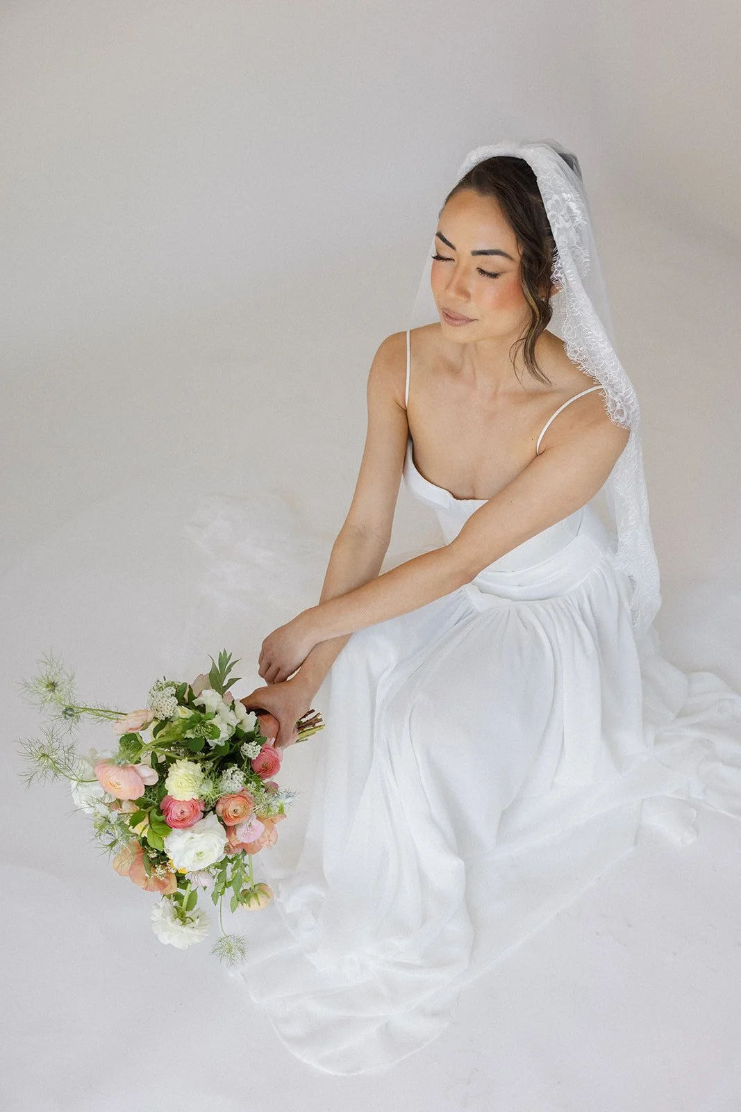 Sitting-bride-with-bouquet-and-veil-studio-session
