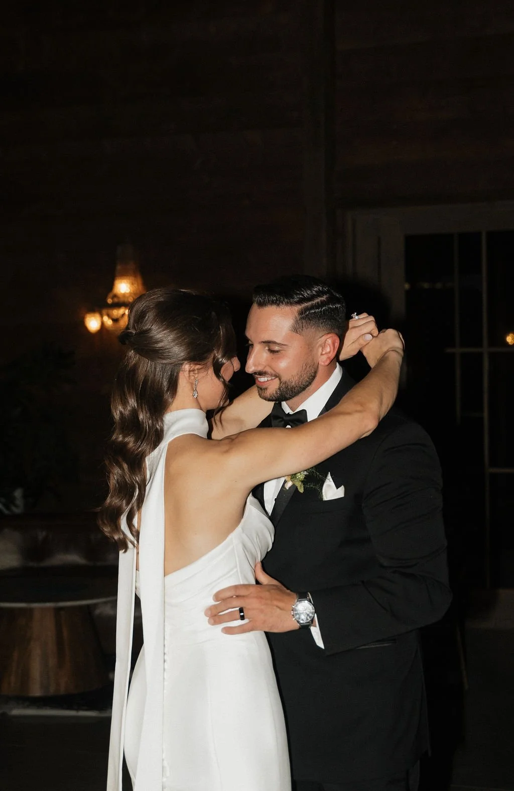 bride and groom dancing at their reception with a flash so the background is very dark 