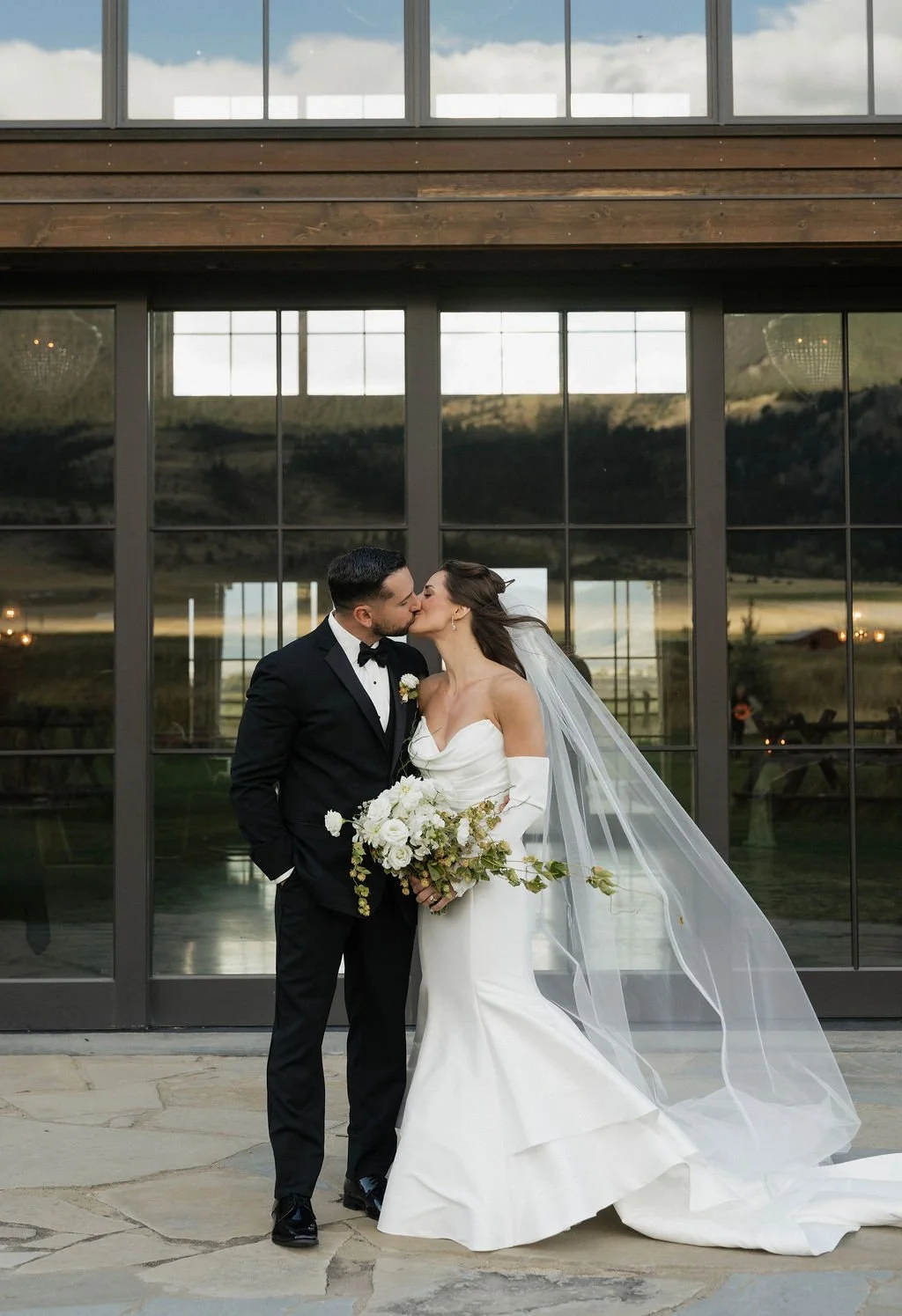 bride and groom kissing with hops and white and texture bouquet at copper rose ranch