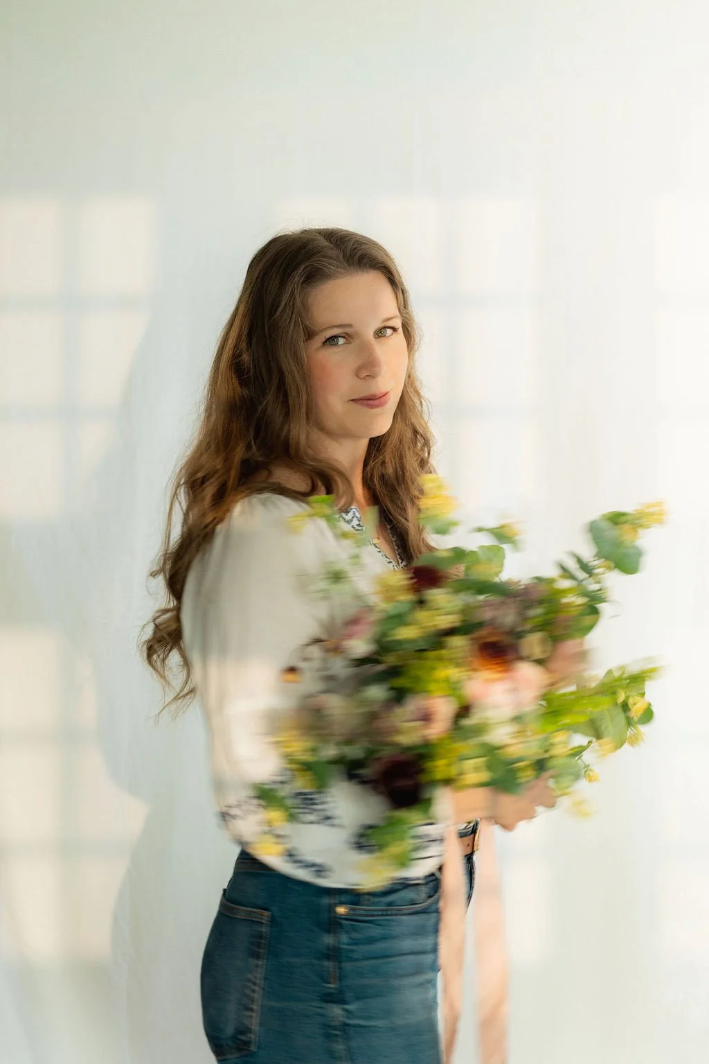 bozeman montana Florist Hannah Ohman with blurry bouquet hand tied with blush silk ribbon