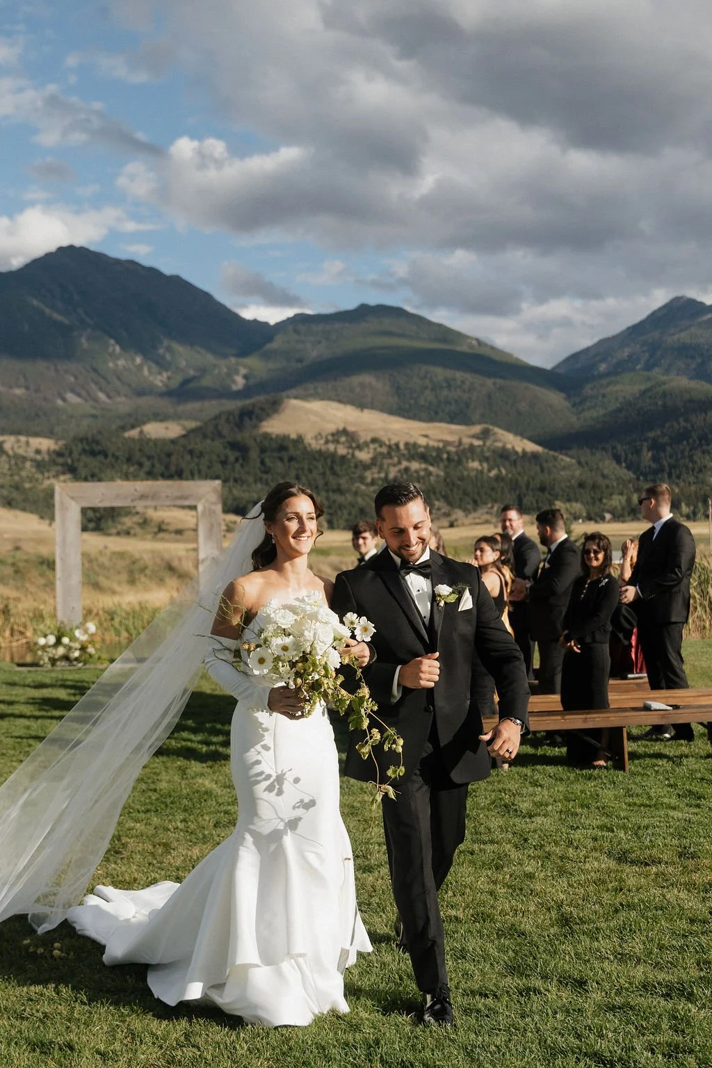 bride and groom so happy as they walk away from the ceremony with her cascading bouquet in her hand