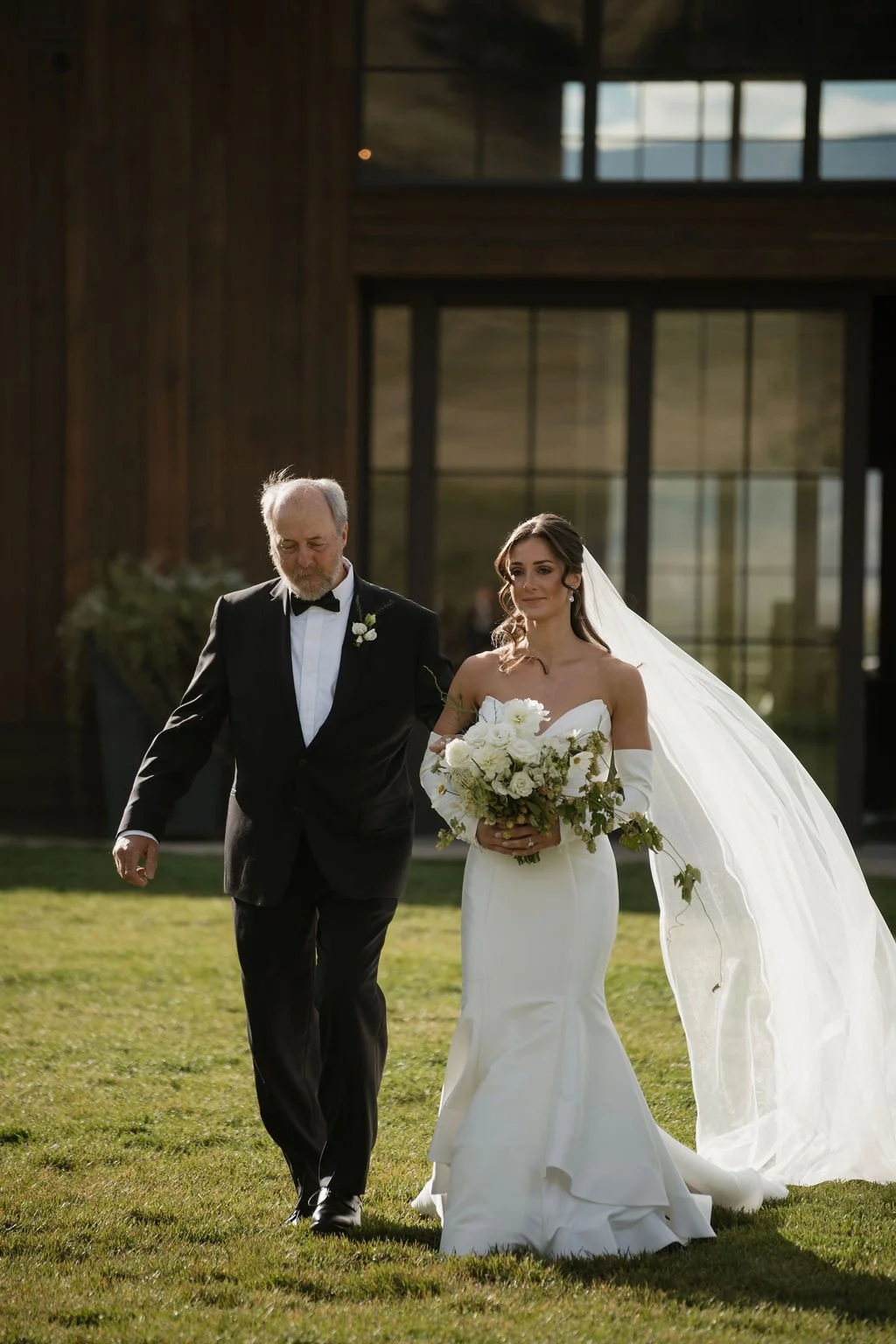 the bride and her father walking down the aisle from the barn at copper rose ranch