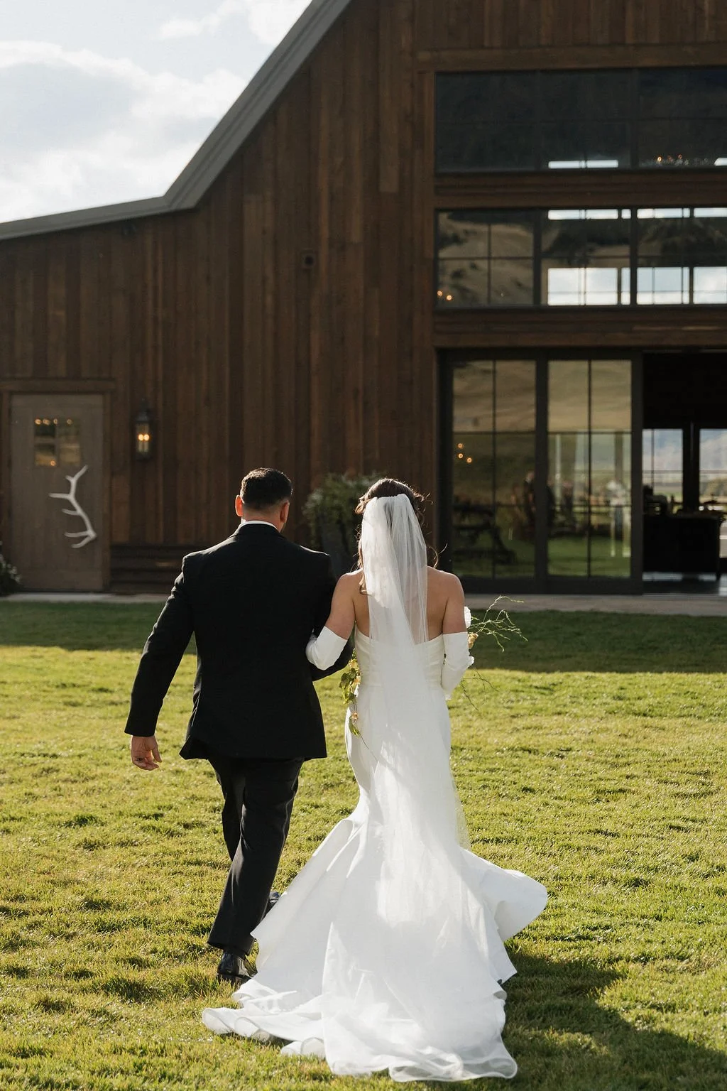 bride and groom from behind walking back toward copper rose ranch